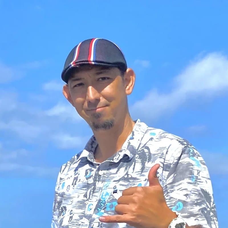 青空の下でシャカサインをするガイドのKEN